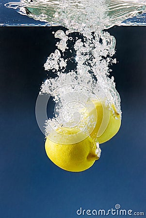 Couple of lemons plunged in blue water Stock Photo