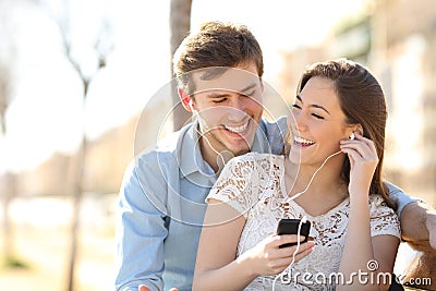 Couple listening to the music from a smart phone Stock Photo