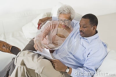 Couple Looking At Bills Worried With Home Finances Stock Photo