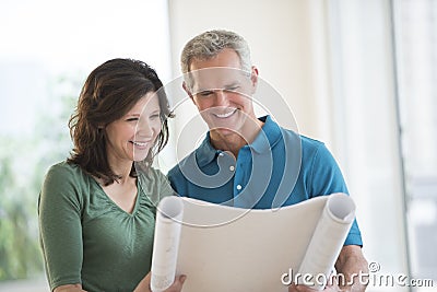 Couple Looking At Blueprint In New House Stock Photo