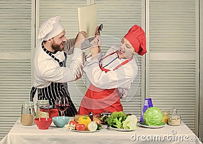Couple in love cooking healthy recipe. Couple fight for book recipes. Improve cooking skill. Book recipes. Helpful Stock Photo