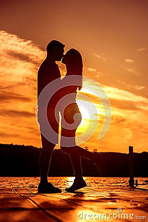 Couple Love Embrace, silhouette at sunrise Stock Photo