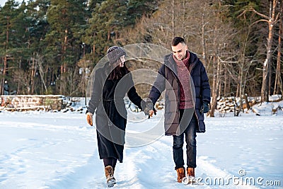 Couple in love holding hands and walking together in park in winter Stock Photo