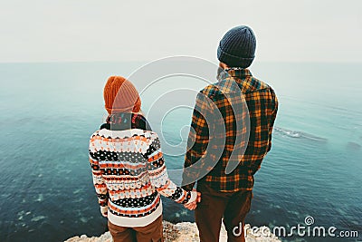 Couple in love Man and Woman holding hands together above sea on cliff Travel happy emotions Lifestyle concept. Young family trave Stock Photo