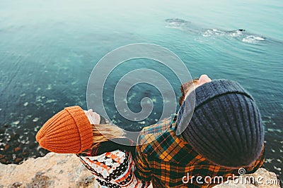 Couple in love Man and Woman together above sea on cliff looking up Traveling happy emotions Lifestyle concept. Young family at ro Stock Photo