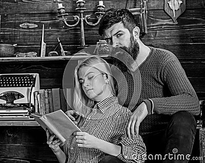 Couple in love reading poetry in warm atmosphere. Lady and man with beard on dreamy faces with book, reading romantic Stock Photo