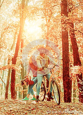 Couple in love ride bicycle together in forest park. Bearded man and woman relaxing in autumn forest. Romantic couple on Stock Photo