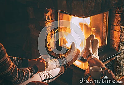 Couple in love sitting near fireplace. Legs in warm socks close Stock Photo