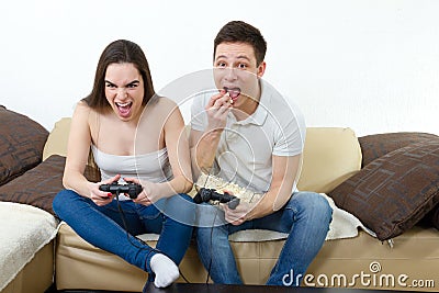 Couple in love on sofa sitting and playing video games in living Stock Photo