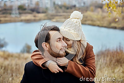 Couple in love walking in the autumn Park, cool fall weather. A man and a woman embrace and kiss, love and affection yellow autumn Stock Photo