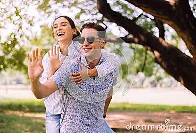 Couple in love woman riding on back of man at park,Romantic and enjoying in moment of happiness time,Happy and smiling Stock Photo