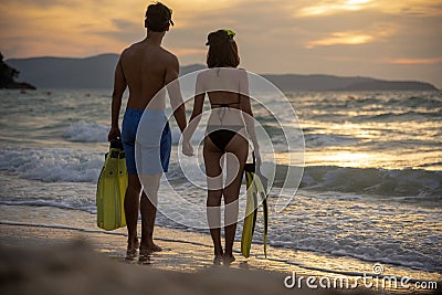 Couple lover holding hands together on the beach during sunset on honeymoon trip at tropical summer island. Honeymoon adventure Stock Photo