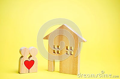 A couple of lovers is standing near the house. The concept of finding an apartment or house. Affordable housing for young families Stock Photo