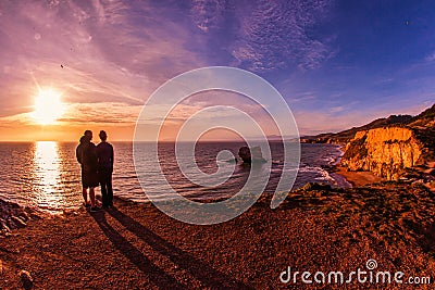 Couple lovers at sunset with purple over pacific ocean coast Editorial Stock Photo