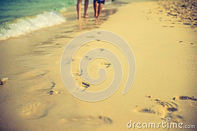 Couple of lovers walking on the each at sunrise - Foot prints the beach Stock Photo