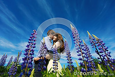 Couple in lupine flowers field Stock Photo