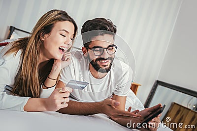 Couple Lying In Bed Using Tablet Computer Stock Photo