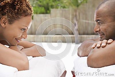 Couple Lying Face To Face On Massage Tables Stock Photo