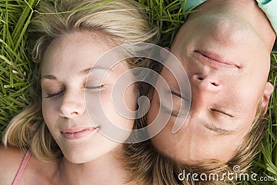 Couple lying in grass sleeping Stock Photo