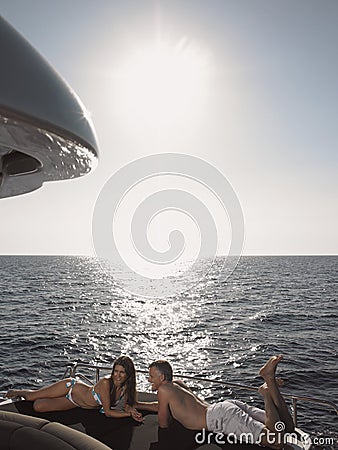 Couple Lying On Yacht's Edge Stock Photo