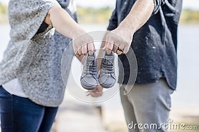 Couple Makes Baby Announcement with a Tiny Pair of Shoes Outside Stock Photo