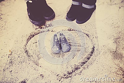 Couple Makes Baby Announcement with a Tiny Pair of Shoes Outside Stock Photo
