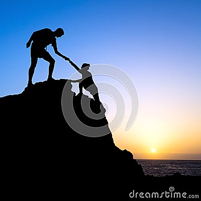 Couple, Man and woman help silhouette in mountains Stock Photo