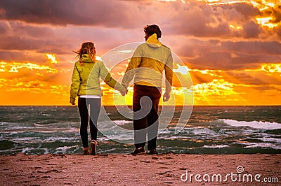 Couple Man and Woman in Love walking on Beach seaside holding hand in hand Stock Photo