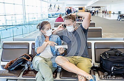 Couple with mask stuck in airport no able to return home country due to COVID-19 border closures Stock Photo