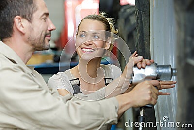 Couple mechanics changing wheel tractor Stock Photo