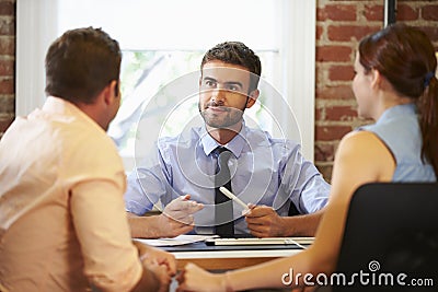 Couple Meeting With Financial Advisor In Office Stock Photo