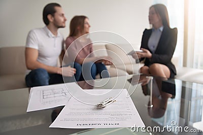Couple meeting with realtor, focus on rental agreement and keys Stock Photo