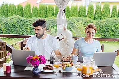 Couple of modern freelancers working during breakfast on terrace Stock Photo