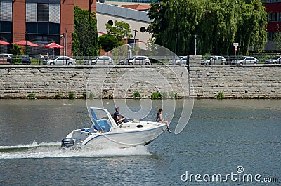 A couple in a motor boat in the river. Woman sit on rostrum of a Editorial Stock Photo