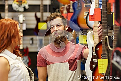 Couple of musicians with guitar at music store Stock Photo