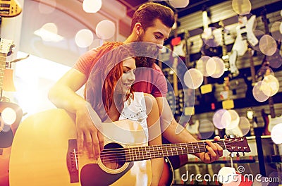 Couple of musicians with guitar at music store Stock Photo