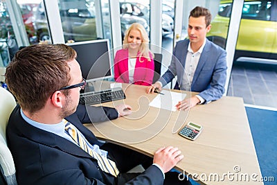 Couple negotiating sale contact for car Stock Photo