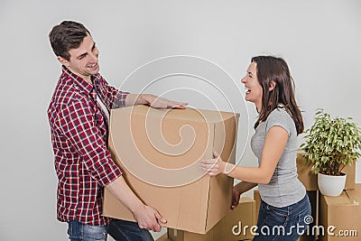 Couple in a new flat. Young man is totaly exhausted. He can not hold heavy box anymore, he almost dropped it, but woman Stock Photo