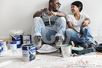 Couple painting house wall taking break Stock Photo