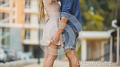 Couple passionately embracing in city street, tender relationship, safe sex Stock Photo