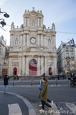 A Couple of pedestrians walking on the zebra crossing in front of the Parish Church of Saint-Paul of Saint-Louis Editorial Stock Photo