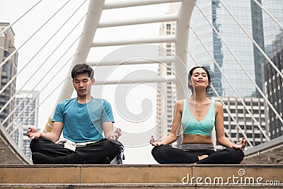 couple perform lotus hand pose yoga in city Stock Photo