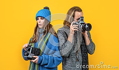 Couple of photojournalists hold photo cameras taking photograph yellow background, paparazzi Stock Photo