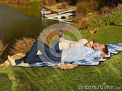 Couple, picnic and lying by lake with wine outdoor, having fun and bonding on vacation. Portrait, alcohol and man and Stock Photo