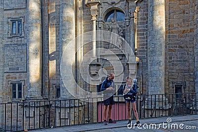 Couple of pilgrims in front of the facade of San Francisco convent Editorial Stock Photo