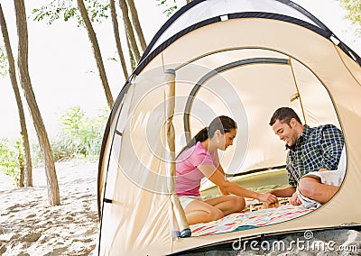 Couple playing boardgame in tent Stock Photo