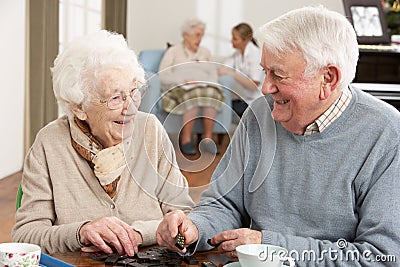 Couple Playing Dominoes At Day Care Centre Stock Photo
