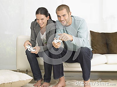 Couple Playing Video Game On Sofa Stock Photo