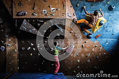 Couple practicing rock-climbing on a rock wall Stock Photo