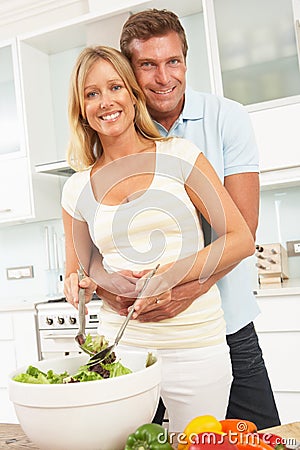 Couple Preparing Salad In Modern Kitchen Stock Photo
